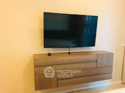 Modern living room with sleek wall-mounted TV and stylish wooden cabinet.