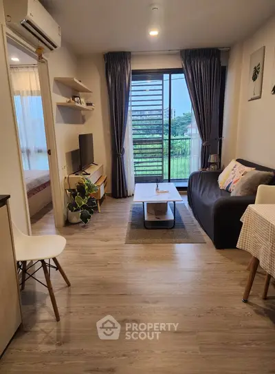 Modern living room with balcony view, stylish decor, and cozy ambiance.