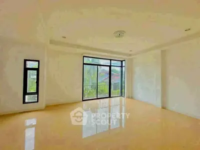 Spacious empty room with large windows and balcony view