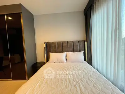 Modern bedroom with stylish bed and large window offering natural light