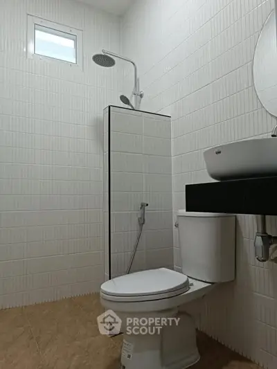 Modern bathroom with sleek white tiles and contemporary fixtures.