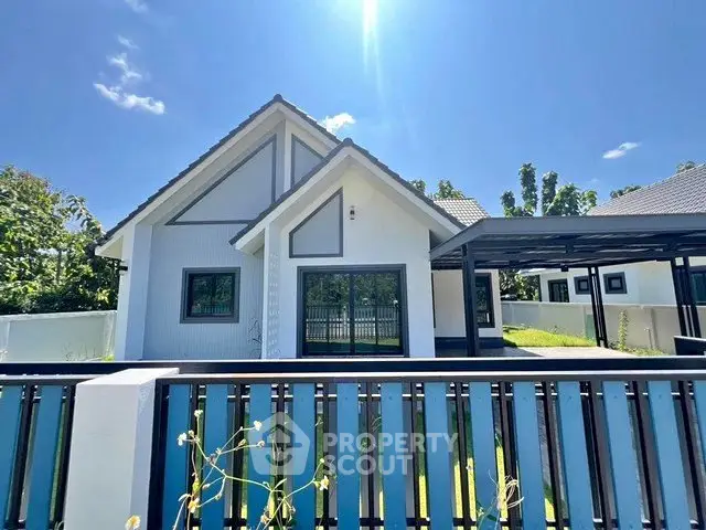 Charming modern house with pitched roof and spacious yard under clear blue sky.