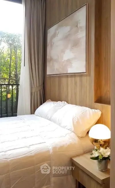 Cozy bedroom with elegant decor and natural light, featuring a plush bed and stylish artwork.