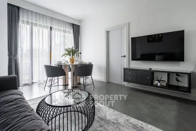 Modern living room with sleek decor and large TV, perfect for relaxation and entertainment.