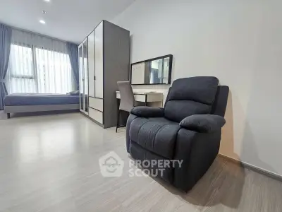 Modern bedroom with cozy armchair and sleek furniture, perfect for relaxation and comfort.