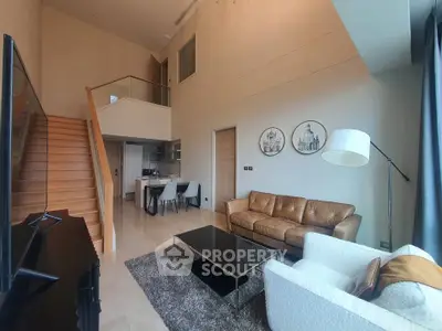Luxurious modern living room with high ceiling and elegant staircase in a stylish apartment.