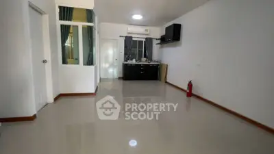 Spacious unfurnished room with glossy floors and a small kitchen area, ideal for customization.