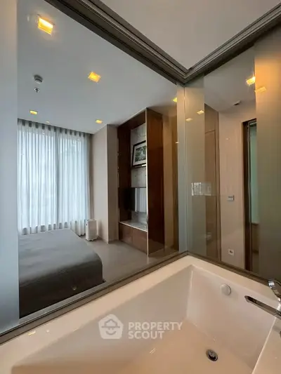 Luxurious bedroom with modern ensuite bathroom featuring a sleek bathtub and elegant decor.