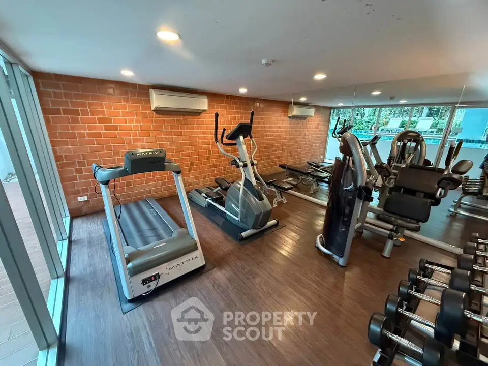Modern gym with state-of-the-art equipment and large windows for natural light.