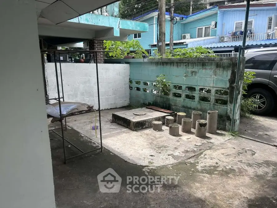 Outdoor area with concrete flooring and blue wall, potential for renovation.