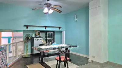 Charming dining area with ceiling fan and pastel walls, featuring a cozy table setup and modern decor.