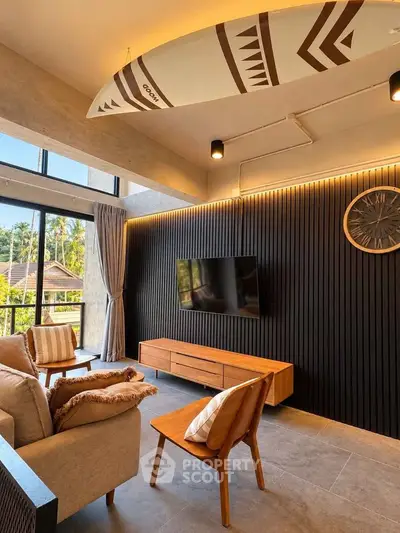 Stylish living room with modern decor, surfboard ceiling art, and large windows offering a scenic view.