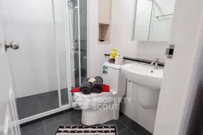Modern bathroom with sleek fixtures and glass shower enclosure.