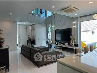 Luxurious modern living room with sleek design and large TV, perfect for entertainment.