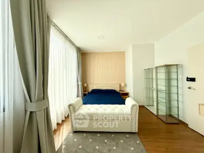 Spacious bedroom with elegant decor and large windows for natural light