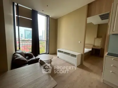 Modern apartment interior with cozy living area and city view, featuring sleek furniture and natural light.