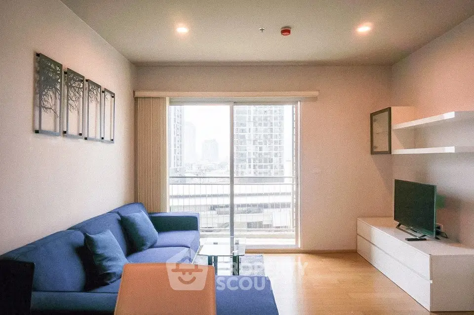 Modern living room with blue sofa, large window, and city view in a stylish apartment.