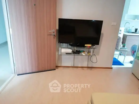 Modern living room with wall-mounted TV and open kitchen layout