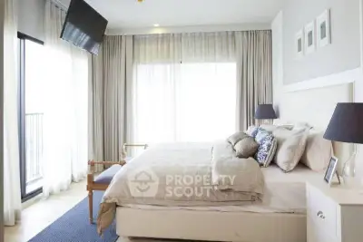 Luxurious bedroom with elegant decor and large windows offering natural light