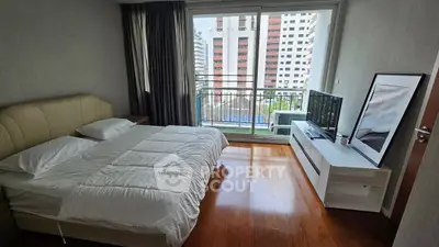 Spacious bedroom with balcony view in modern apartment