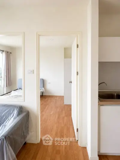 Modern apartment interior with wooden flooring and sleek kitchen design