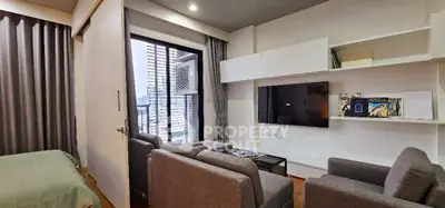 Modern living room with sleek furniture and city view balcony in a stylish apartment.