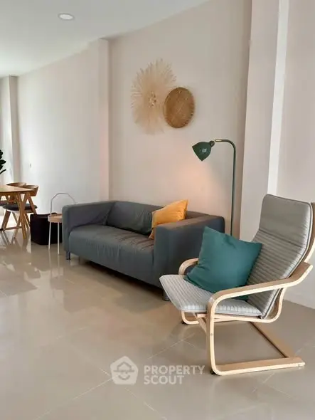 Modern living room with stylish furniture and elegant decor, featuring a cozy sofa and chic armchair.