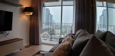 Modern living room with cozy sofa and city view from large windows, perfect for urban living.