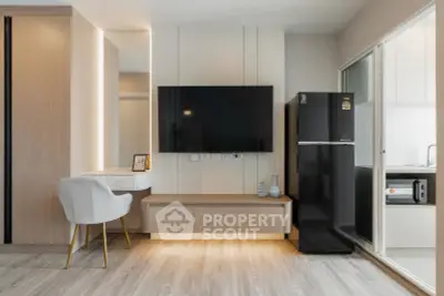 Modern living room with sleek TV setup and adjacent kitchen area