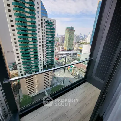 Stunning city view from a modern high-rise balcony with glass railing.
