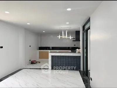 Modern open-plan kitchen with sleek design and marble flooring