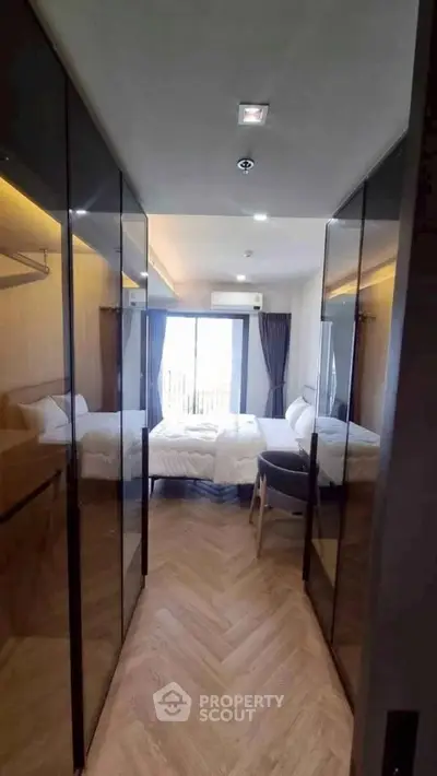 Modern bedroom with glass wardrobes and balcony view in luxury apartment