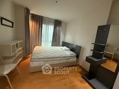 Spacious bedroom with modern furnishings and large window for natural light.