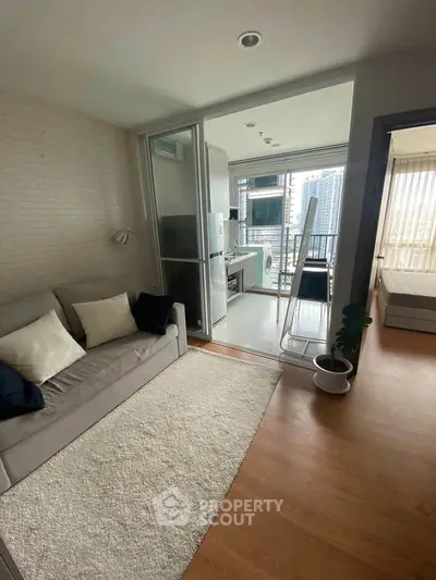 Modern apartment with cozy living room and balcony view, featuring stylish decor and natural light.