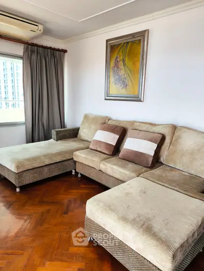 Spacious living room with cozy sectional sofa and elegant parquet flooring.