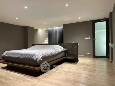 Spacious modern bedroom with sleek design and wooden flooring