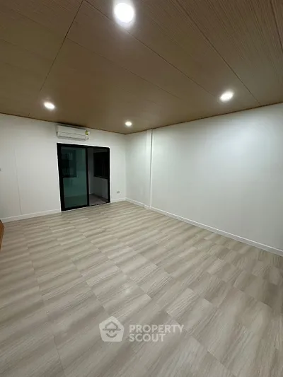 Spacious empty room with modern lighting and air conditioning, ready for customization.