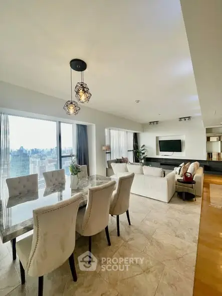 Spacious modern living room with dining area and city view, featuring elegant decor and ample natural light.