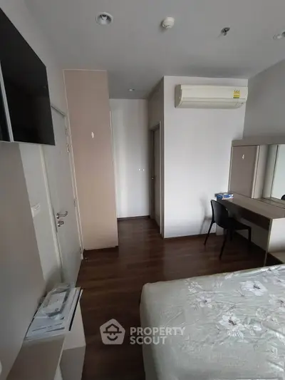 Modern bedroom with air conditioning and sleek wooden flooring