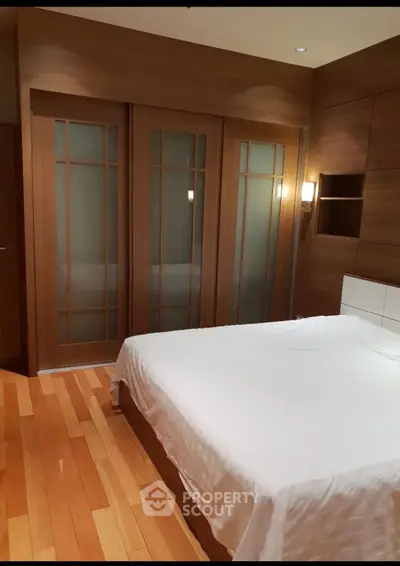 Elegant bedroom with wooden sliding doors and cozy lighting