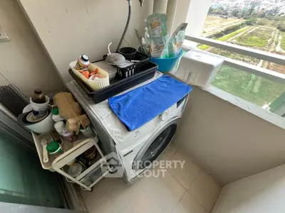 Compact balcony with washing machine and storage overlooking scenic view.