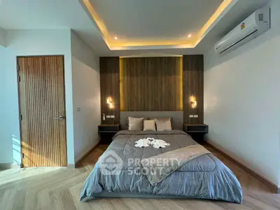 Modern bedroom with stylish lighting and cozy bedding in a contemporary apartment.