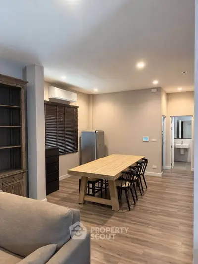 Modern open-plan living room with dining area and sleek wooden flooring