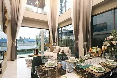 Luxurious double-height living room with elegant decor and large windows offering stunning views.