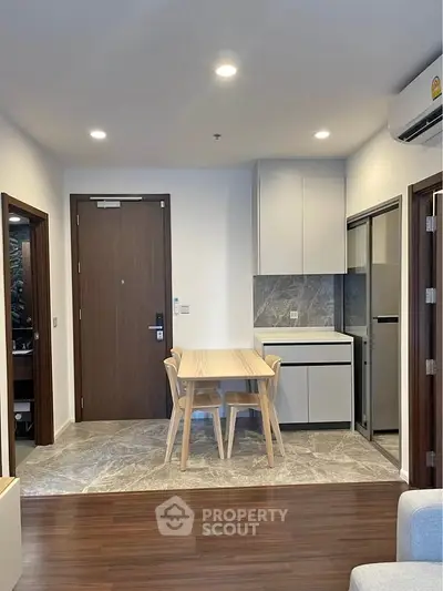 Modern apartment interior with stylish dining area and compact kitchen design.
