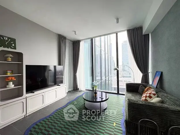 Modern living room with floor-to-ceiling windows and city view, featuring stylish decor and a cozy seating area.