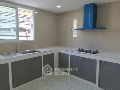 Modern kitchen with sleek cabinetry and gas stove in a bright corner unit