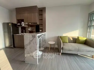 Modern open-plan living room with stylish kitchen and cozy seating area.