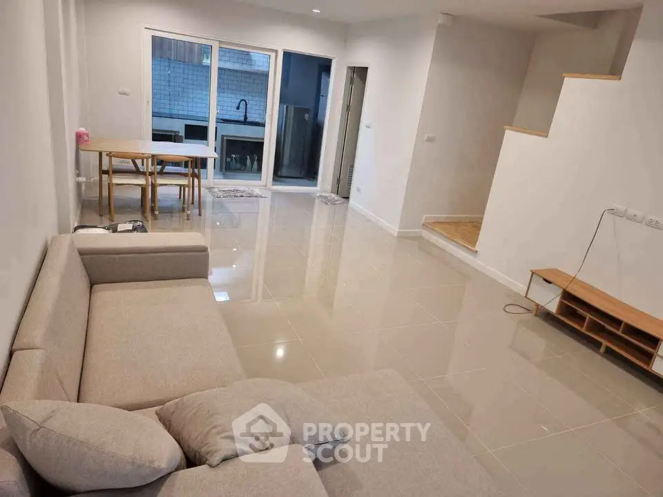 Spacious modern living room with sleek tile flooring and cozy sofa