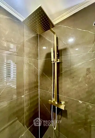 Luxurious modern bathroom with sleek rainfall showerhead and elegant marble tiles.